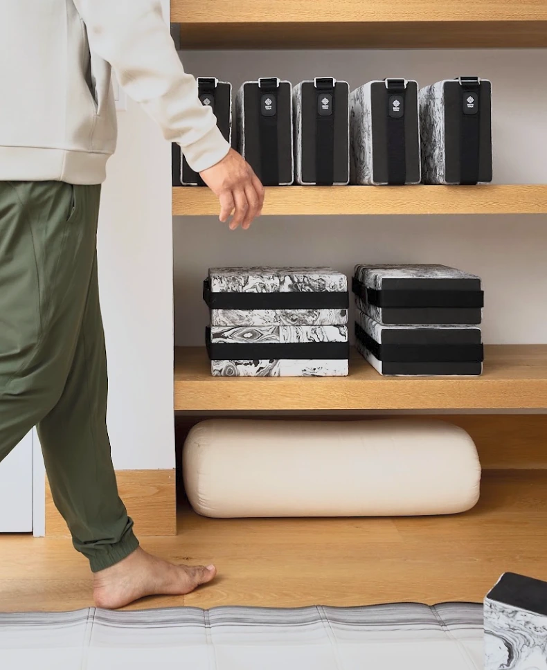 Bento Yoga ONE kits and blocks stacked neatly on studio shelves