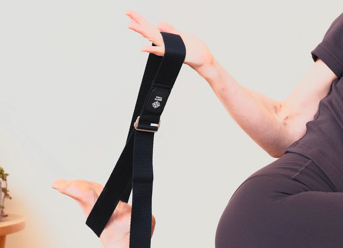 Hands holding the adjustable Bento Yoga cotton strap and metal buckle
